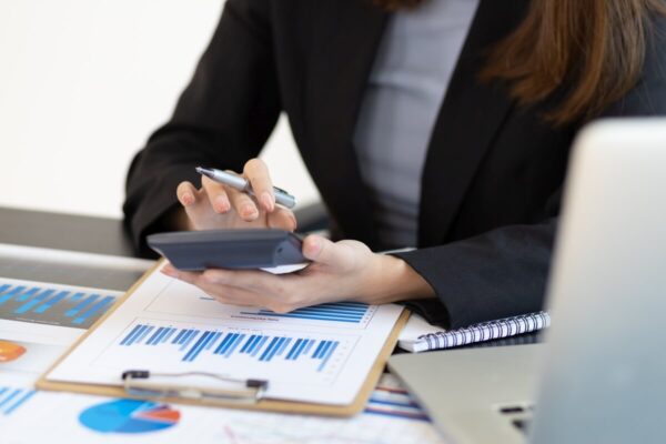 Księgowa sprawdza dane na kalkulatorze.