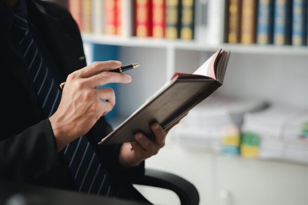 Mężczyzna w garniturze przegląda dokumenty związane z usługami księgowymi w biurze.