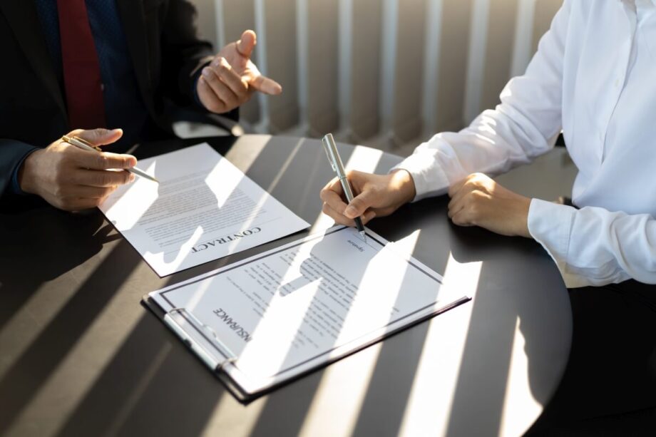 Osoby podpisują dokumenty związane z zakładaniem spółek.