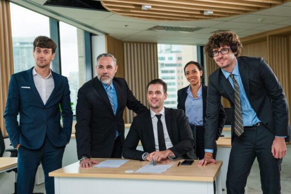 Grupa biznesmenów przy stole omawia zakładanie spółek.