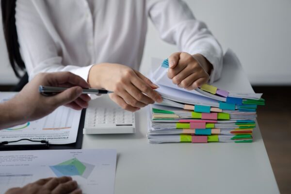 Na stole leżą dokumenty, które są przeglądane w ramach usługi księgowe.