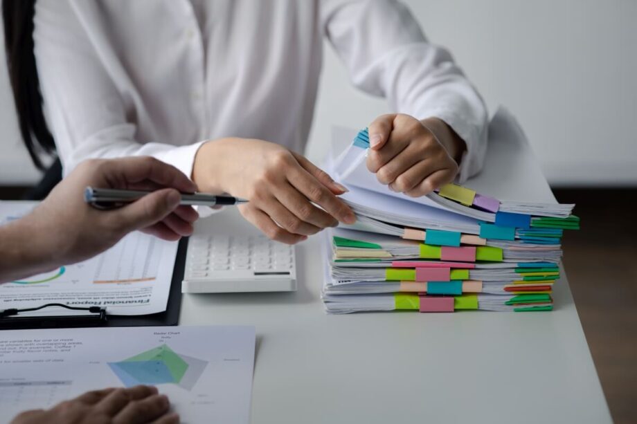 Na stole leżą dokumenty, które są przeglądane w ramach usługi księgowe.