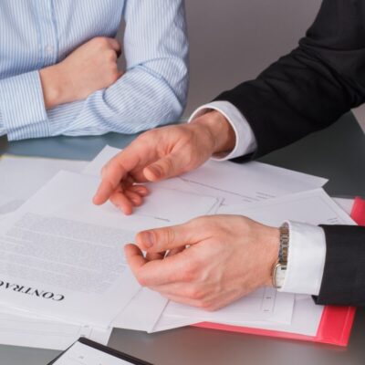 Dwie osoby omawiają dokumenty dotyczące zakładania spółek.