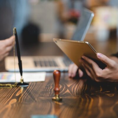 Osoby omawiają dokumenty związane z pełną księgowością przy biurku.