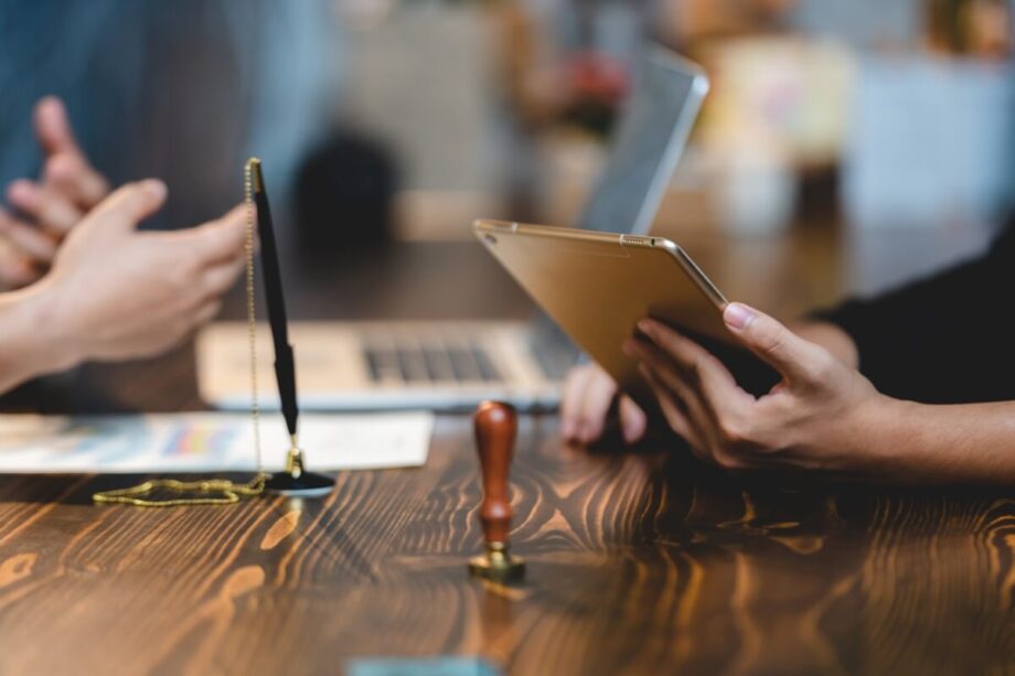 Osoby omawiają dokumenty związane z pełną księgowością przy biurku.