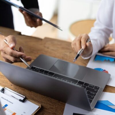 Osoby pracujące przy komputerze omawiają raporty w biurze rachunkowym.