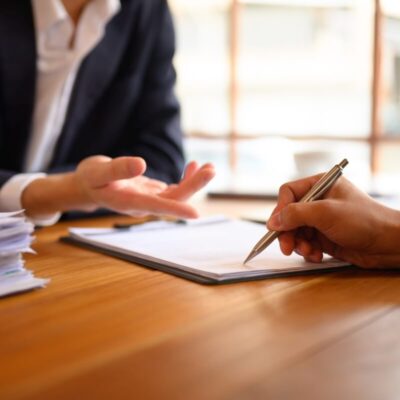 Osoby omawiają dokumenty na temat zakładania spółek.