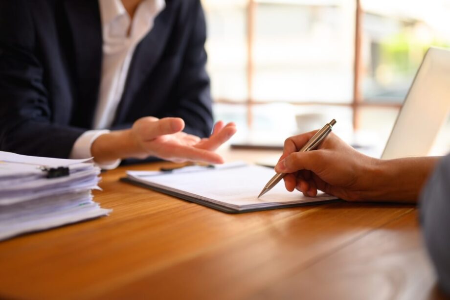 Osoby omawiają dokumenty na temat zakładania spółek.
